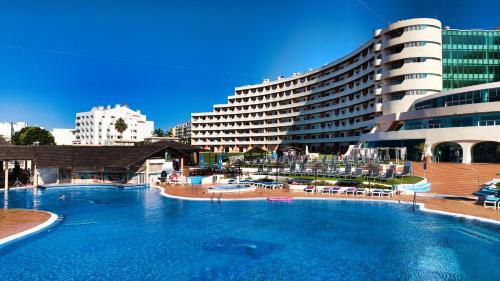 a large swimming pool in front of a hotel at Hotel Apartamento Paraiso De Albufeira in Albufeira
