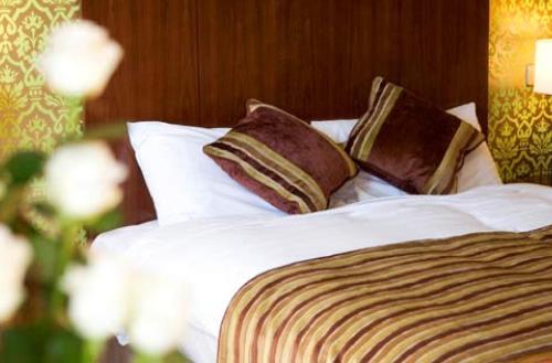 a bed with white sheets and pillows at George Limerick Hotel in Limerick