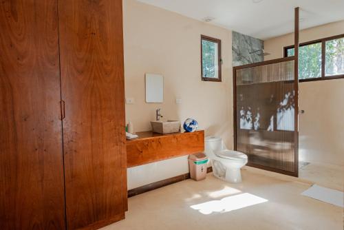 a bathroom with a toilet and a glass shower at Villas AHAL, in Chemuyil
