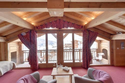 a living room with a large window with a view at Hôtel L'Accroche Coeur in La Rosière