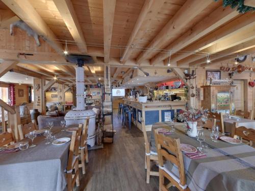 a restaurant with tables and chairs and a stove at Hôtel L'Accroche Coeur in La Rosière