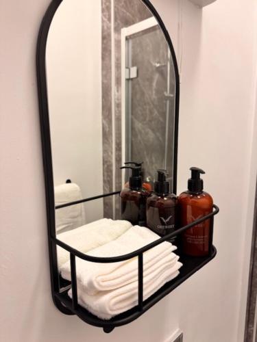 a mirror on a wall with towels and soap at The Wrey Arms in Barnstaple