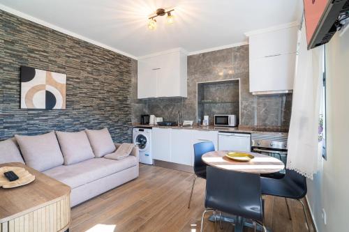 a living room and kitchen with a couch and a table at GuestReady - Casa do Feno in Santa Cruz