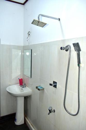 a bathroom with a sink and a shower at Upali Homestay in Kandy