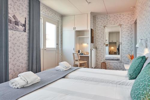 a bedroom with a large bed with towels at Klippen Hotel - Therns in Gudhjem