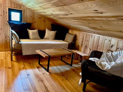 una stanza con un letto, un tavolo e un divano di Esprit-cabane a Lège-Cap-Ferret
