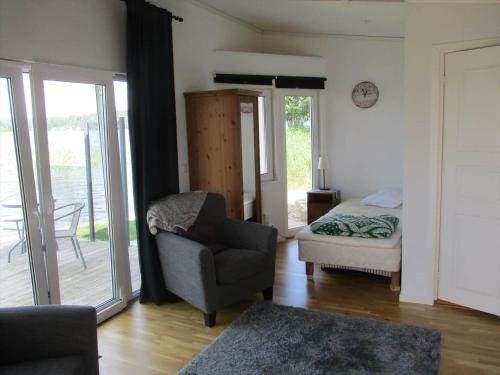 a living room with a chair and a bed at OGO827-Vreta-Kloster-Sjoebacka-17 in Vreta Kloster