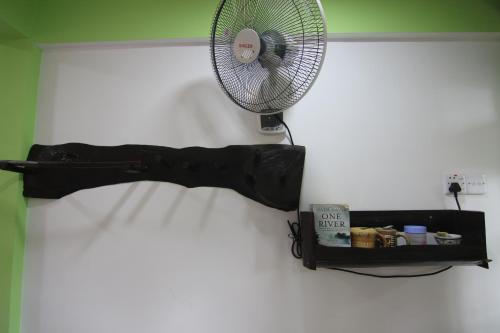 a white fan on a wall next to a shelf at Villa Eden Paradise in Ella