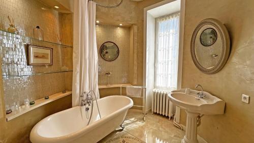 a bathroom with a bath tub and a sink at Château de la Chabroulie in Isle