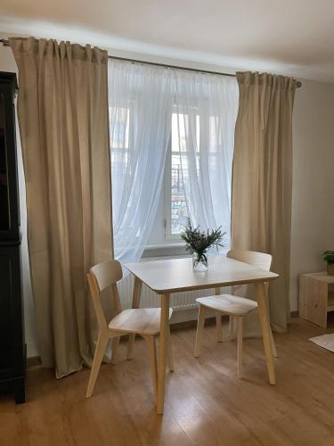 a table and chairs in a room with a window at Apartmán Monarchia in Banská Štiavnica