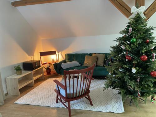 a living room with a christmas tree and a chair at Apartmán Monarchia in Banská Štiavnica