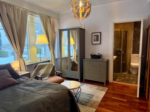 a living room with a bed and a bathroom at Hills Cottage Holiday Homes in Gränna