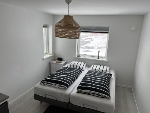 a bedroom with a bed with two pillows on it at Private apartment with panoramic ocean views in Ilulissat