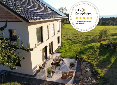 a house with a table and chairs on a patio at 5 Sterne Ferienwohnung Villa Barka in Eppenschlag