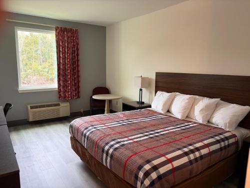 a hotel room with a bed and a window at Regency Inn & Suites in Milton