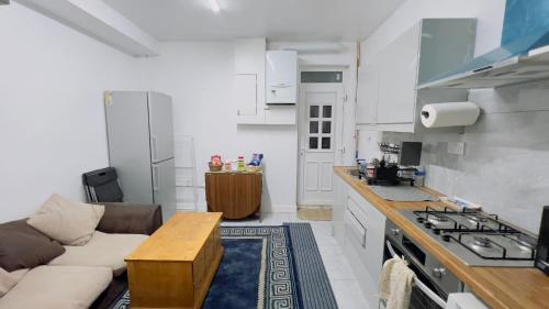 a kitchen with a couch and a table in a room at Manchester City Cosy Stay - Fresh New Master bedroom Sleeps 3 Guests - 3 Adults in Manchester