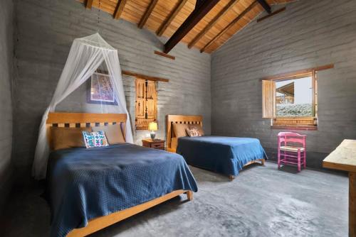 a bedroom with two beds and a window at Casa Estrella, Mountain View in Malinalco