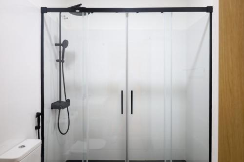 a glass shower in a bathroom with a toilet at GUMBELA - Hotel in São Tomé