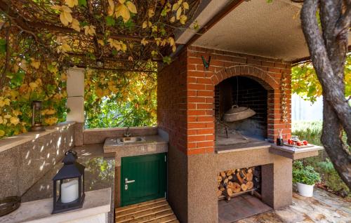 una cocina al aire libre con chimenea de ladrillo y puerta verde en Apartment Davor & Davorka, en Marina