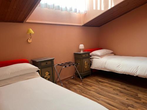 a room with two beds and a window and two lamps at Urban Po Mansarda in Santa Maria Maddalena