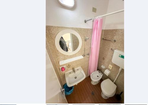 a bathroom with a sink and a toilet and a mirror at Hotel Britta in Rimini