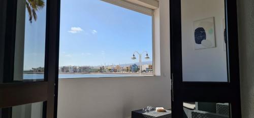a window in a room with a view of the ocean at Apartamento en primera línea de la playa in Arinaga