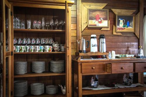 a kitchen with plates and dishes on shelves at Pousada Fogo Eterno in Urubici