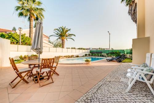 a patio with a table and chairs and a pool at Altura Prime 5 Suite Villa with Private Pool and Parking Walk to Beach in Altura