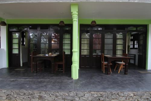 a room with two tables and chairs and windows at Villa Eden Paradise in Ella