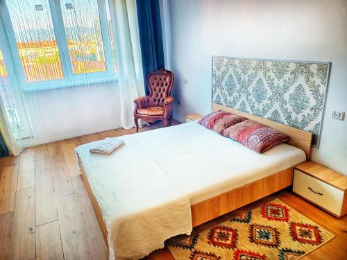 a bedroom with a large bed and a chair at Studio Miruna in Piatra Neamţ