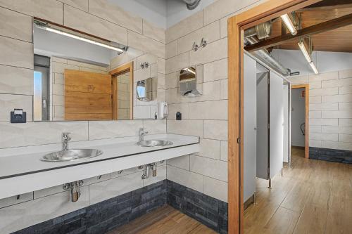 a bathroom with two sinks and a mirror at Albergue La Santa Siesta in Villadangos del Páramo