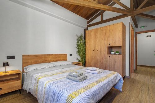 a bedroom with a bed with towels on it at Albergue La Santa Siesta in Villadangos del Páramo