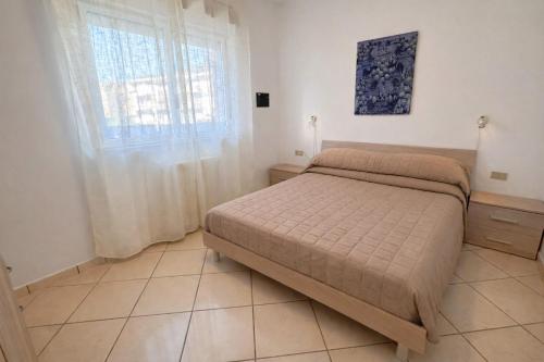 a small bedroom with a bed and a window at Appartamenti La Mer in San Benedetto del Tronto