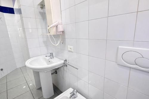 a white bathroom with a sink and a toilet at Appartamenti La Mer in San Benedetto del Tronto