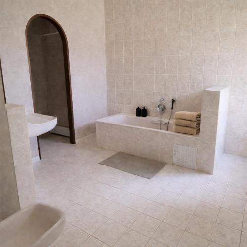 a white bathroom with a tub and a sink at Chambres de charme - 2 chambres indépendantes avec salles de bains privatives in Corte