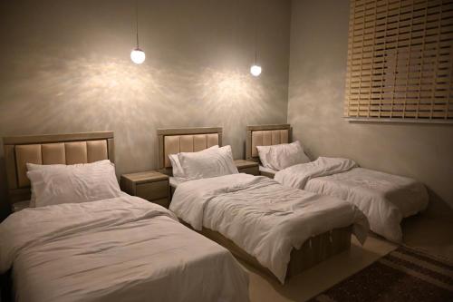 two beds in a room with white sheets and pillows at شاليه لانتانا in Taif