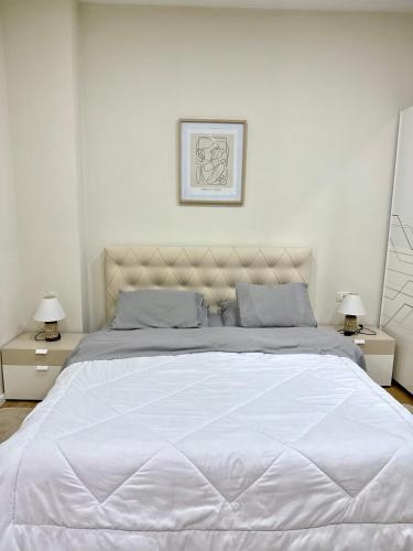 a bedroom with a large white bed with two night stands at Mediterranean Villa Old Town in Vlorë