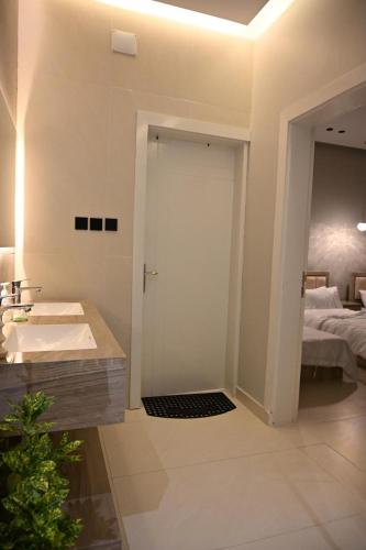 a bathroom with a sink and a door to a bedroom at شاليه لانتانا in Taif