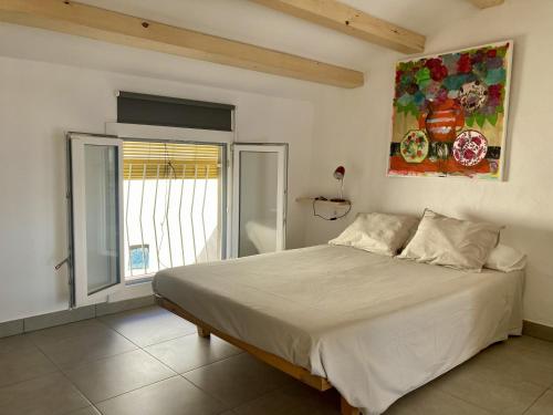 a bedroom with a bed and a painting on the wall at Casa Taller en Penelles in Penellas
