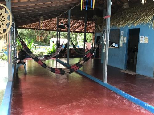 a hammock in a room with a horse in the background at REDÁRIO Botos de Alter in Alter do Chao