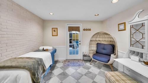 a bedroom with two beds and a blue chair at In-ground pool, hot tub, fire pit, massage room! in Tulsa