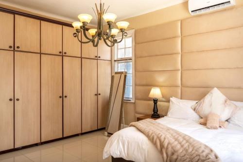 a bedroom with a bed and a chandelier at Pearlstone in Durban