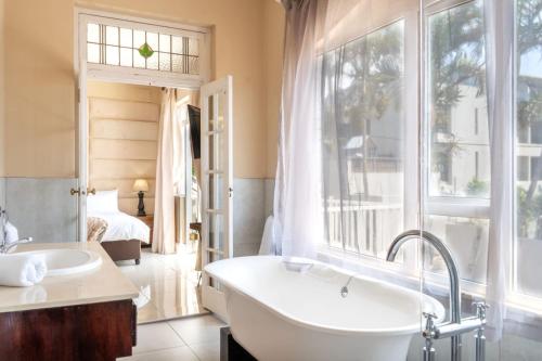 a bathroom with a tub and a large window at Pearlstone in Durban