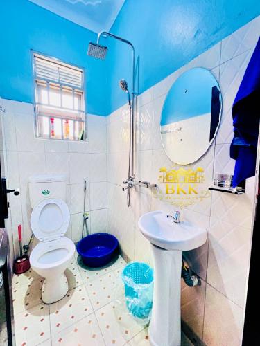 a bathroom with a toilet and a sink and a mirror at BKK Residences in Fort Portal