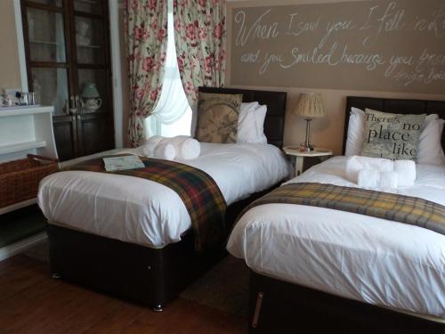 a bedroom with two beds and a quote on the wall at Hooray Henrys Sheringham in Sheringham