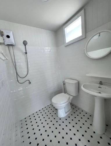 a bathroom with a toilet and a sink and a mirror at Baan Pranai In Pai in Pai