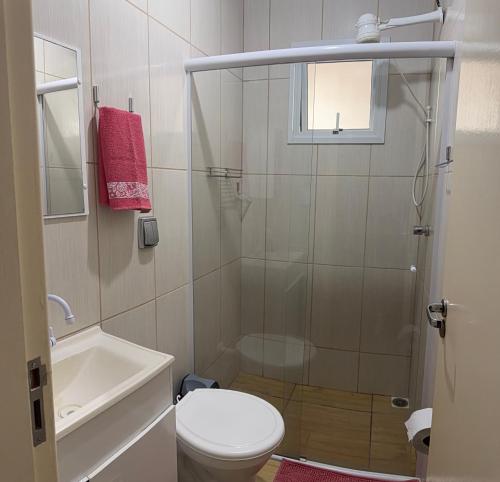 a bathroom with a shower and a toilet and a sink at Apartamento Sunset 101 in Palhoça
