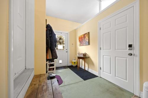 a hallway with yellow walls and a white door at Farmhouse Stay Guelph Elora in Guelph