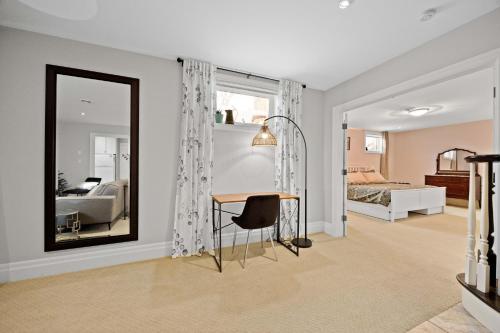 a bedroom with a mirror and a table and a bed at Farmhouse Stay Guelph Elora in Guelph