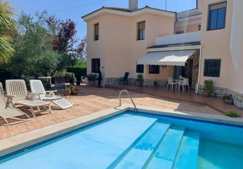 a swimming pool in front of a house at Villa Bobal in Requena